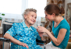 lady assisting old woman to drink water